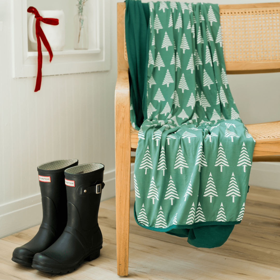 Hug blanket with a pine green background with modern white trees perfect for mountain lovers (or even as Christmas decor).