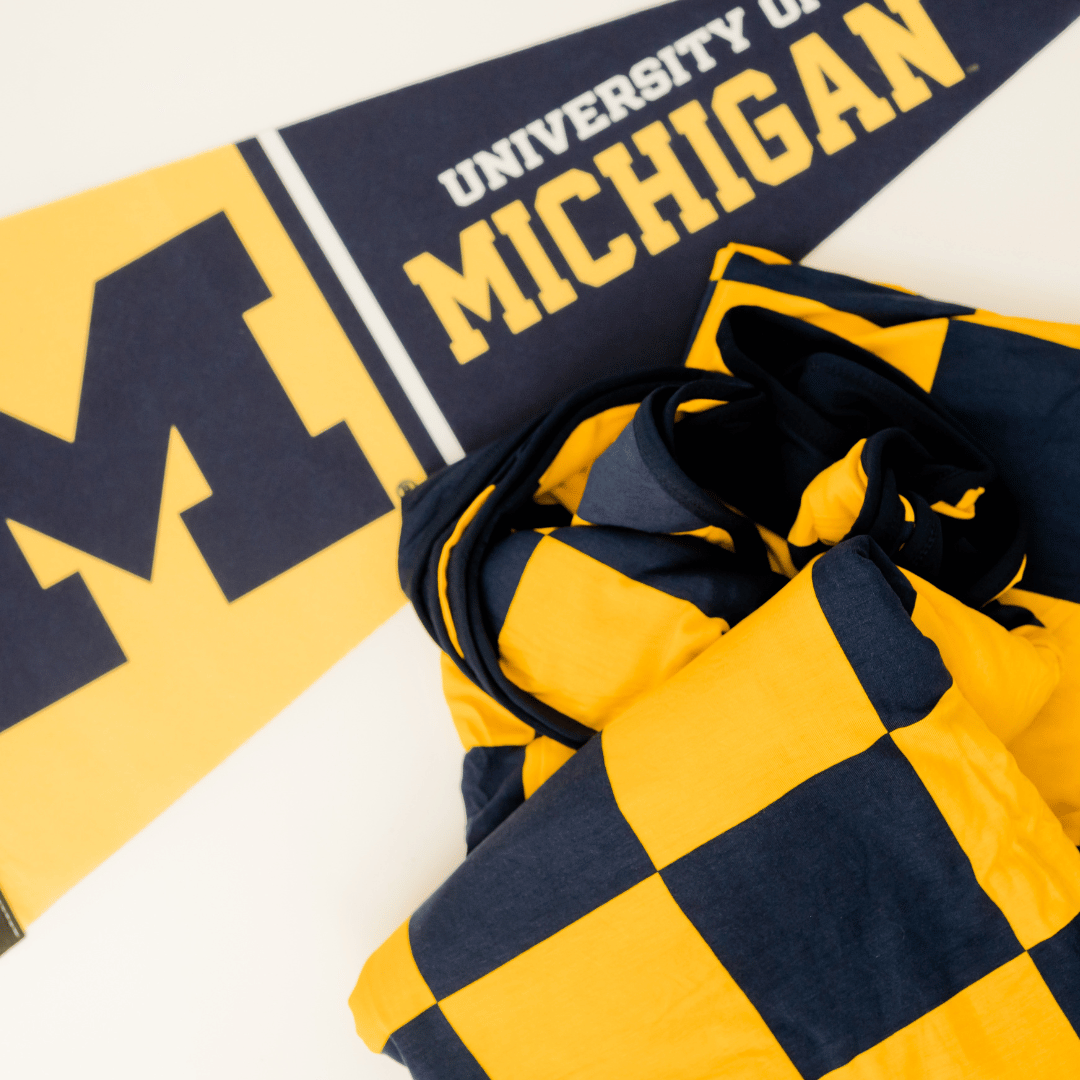 University of Michigan gold and navy blanket for tailgating watchparties and gamedays.
