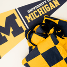 University of Michigan gold and navy blanket for tailgating watchparties and gamedays.